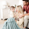 Mom and dad playing with their little boy in a beautiful and cozy light blue Surf RIBBED BAMBONI XL BLANKETS - Saranoni