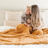 Mom giving daughter a kiss on the cheek, both wrapped in extra stretchy soft Golden Yellow RIBBED BAMBONI® XL BLANKETS - Saranoni