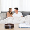 Husband and wife snuggled together in oversized, extra soft and comfy light gray Moonbeam RIBBED BAMBONI XL BLANKETS - Saranoni