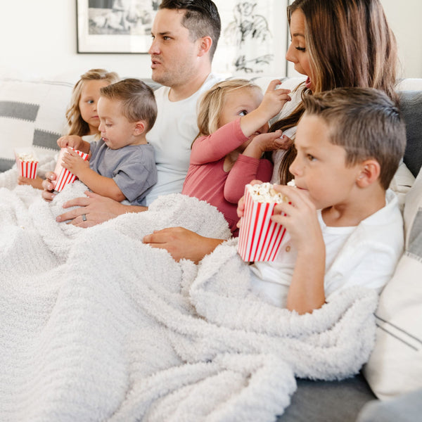 Family enjoying a movie night together with their favorite light gray Moonbeam RIBBED BAMBONI XL BLANKETS - Saranoni