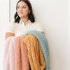 Woman holding out four beautiful colors of RIBBED BAMBONI XL BLANKETS - Saranoni