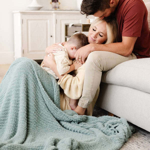 Family snuggling up together with their favorite soft and cozy light blue Surf RIBBED BAMBONI XL BLANKETS - Saranoni