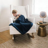 A little boy sits under a Luxury Receiving Navy Colored Lush Saranoni Blanket. The soft blanket is a small blanket and a baby blanket or toddler blanket.