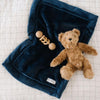 A stuffed animal bear and toy lay on top of a mini Navy Colored Lush Saranoni Blanket. The soft blanket is a small blanket and a baby blanket or toddler blanket.