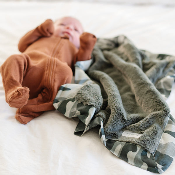 Mini camo blanket with a rich, plush surface and a sleek satin border, designed to provide both warmth and a refined, stylish look.