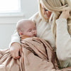 Baby snuggled with a soft mini blanket featuring a satin back for a cozy feel with a smooth, elegant touch.