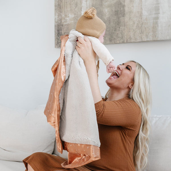 Receiving blanket with a gentle, plush front and a satin back, providing a cozy and elegant wrap for your little one.