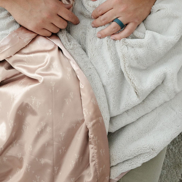 Soft receiving blanket with a satin back, offering cozy warmth with a smooth, luxurious feel.