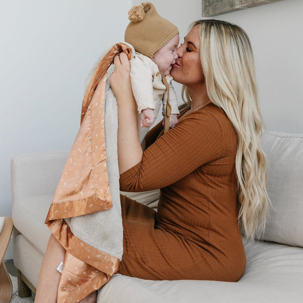 Plush receiving blanket featuring a silky satin back, perfect for keeping your baby warm and comfortable.