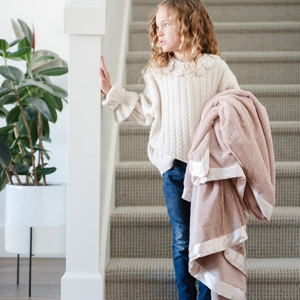 Luxurious toddler blanket with a plush, velvety front and a silky satin back, offering a comforting and elegant wrap for your little one.