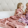 Two girls snuggling with Saranoni toddler blankets with an ultra-soft, cloud-like texture, perfect for wrapping your little one in luxury and warmth.