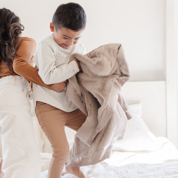 Mother and son enjoying playtime together with a taupe Saranoni toddler blanket.