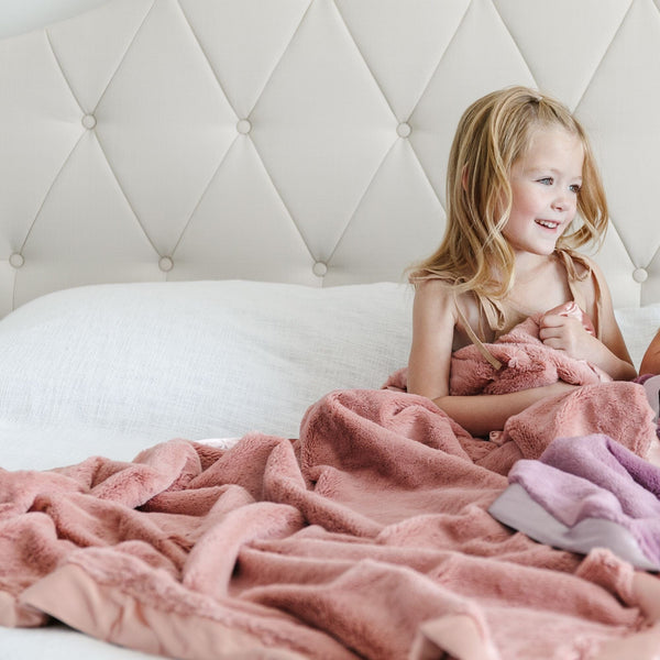 Little girl wrapped in a Saranoni toddler blanket with an ultra-soft, cloud-like texture, perfect for wrapping your little one in luxury and warmth.