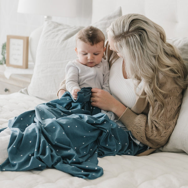 Mom and newborn baby snuggling in denim triangle blanket - STRETCHY SWADDLES - Saranoni