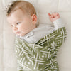 Baby boy snuggling in green STRETCHY SWADDLES - Saranoni