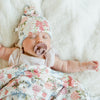 Newborn baby girl falling asleep in floral STRETCHY SWADDLE and matching hat - Saranoni