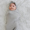 Newborn baby falling asleep in super soft grey STRETCHY SWADDLES - Saranoni