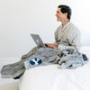 A boy sits with a Luxury Extra Large Oversized Throw Gray Colored Lush Saranoni Blanket. The soft blanket has a soft faux fur feeling. The extra large blanket has the Brigham Young University Logo on it.