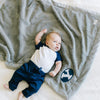 A baby lays on a Luxury Receiving Gray Colored Lush Saranoni Blanket. The soft blanket is a toddler blanket or baby blanket and has a soft faux fur feeling. The blanket has the Brigham Young University Logo on it.