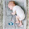 A baby lays on a Luxury Mini Gray Colored Lush Saranoni Blanket. The soft blanket is a small blanket and a toddler or baby blanket and has a soft faux fur feeling. The blanket has the Brigham Young University Logo on it.