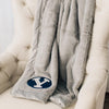 A Luxury Gray Colored Lush Saranoni Blanket. The soft blanket has a soft faux fur feeling. The blanket has the Brigham Young University Logo on it.