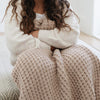 Close-up of young girl cuddling with Wheat Waffle Knit Toddler blanket showing its textured pattern - tan colored Waffle Knit blanket