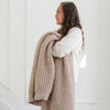 Close-up of young girl holding Wheat Waffle Knit Toddler blanket showing its textured pattern - tan colored Waffle Knit blanket