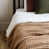 Tan colored twin waffle knit blanket providing a blend of warmth and breathability in a soft, textured fabric.