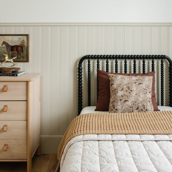 A child's bedroom featuring a cozy, tan colored twin waffle knit blanket. 