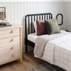 Cozily decorated bedroom featuring a luxurious, light gray waffle knit blanket on the bed. 